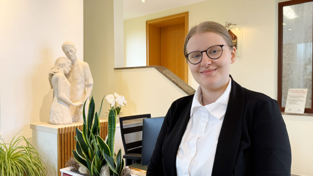 Auszubildende zur Bestattungsfachkraft, Elisabeth Mientkewitz steht bei Henschel Bestattungen am Hauptstandort Berenbostel im Foyer.