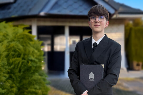 Unser Auszubildender Nino Günsche steht vor der Kapelle in Osterwald. Das Bild ist teilweise KI-generiert. Nino stammt ursprünglich aus Chemnitz und ist für die Ausbildung nach Garbsen gezogen.